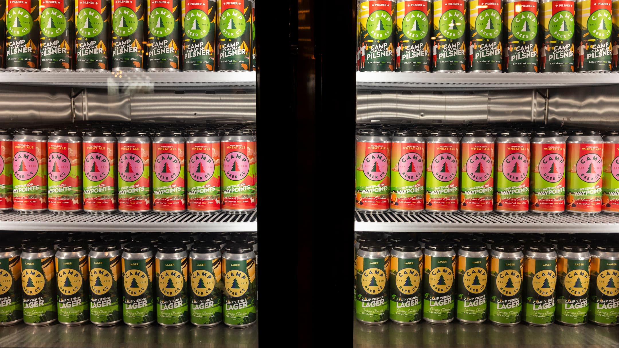 Camp Beer Co. cans on a retail fridge shelf