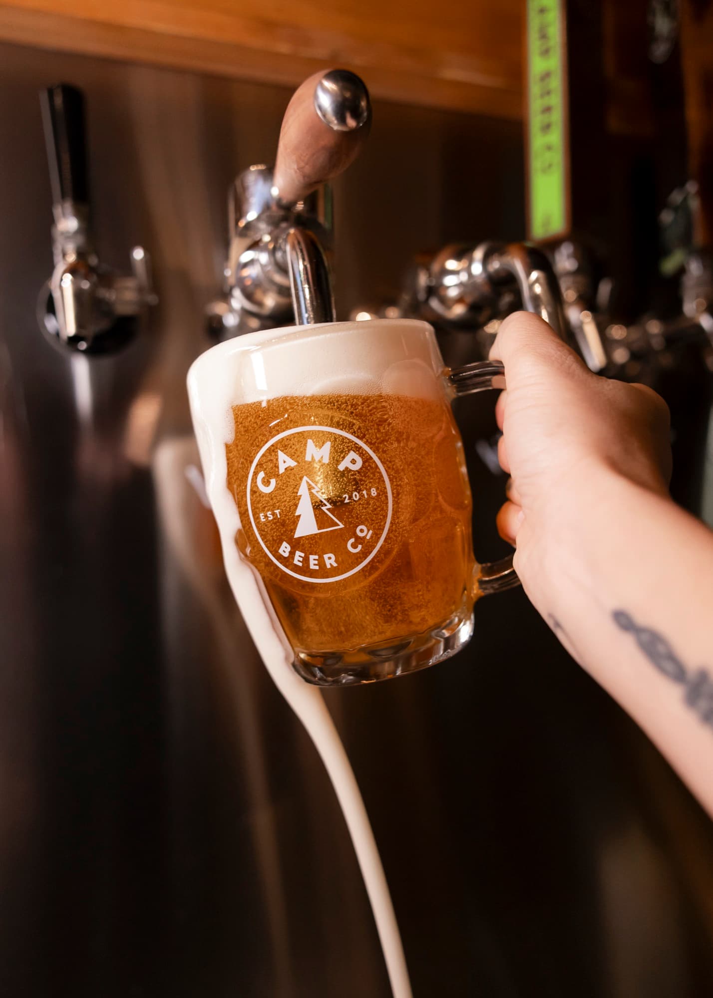 A Camp Beer Co. mug overflowing under the side-pull Lukr tap